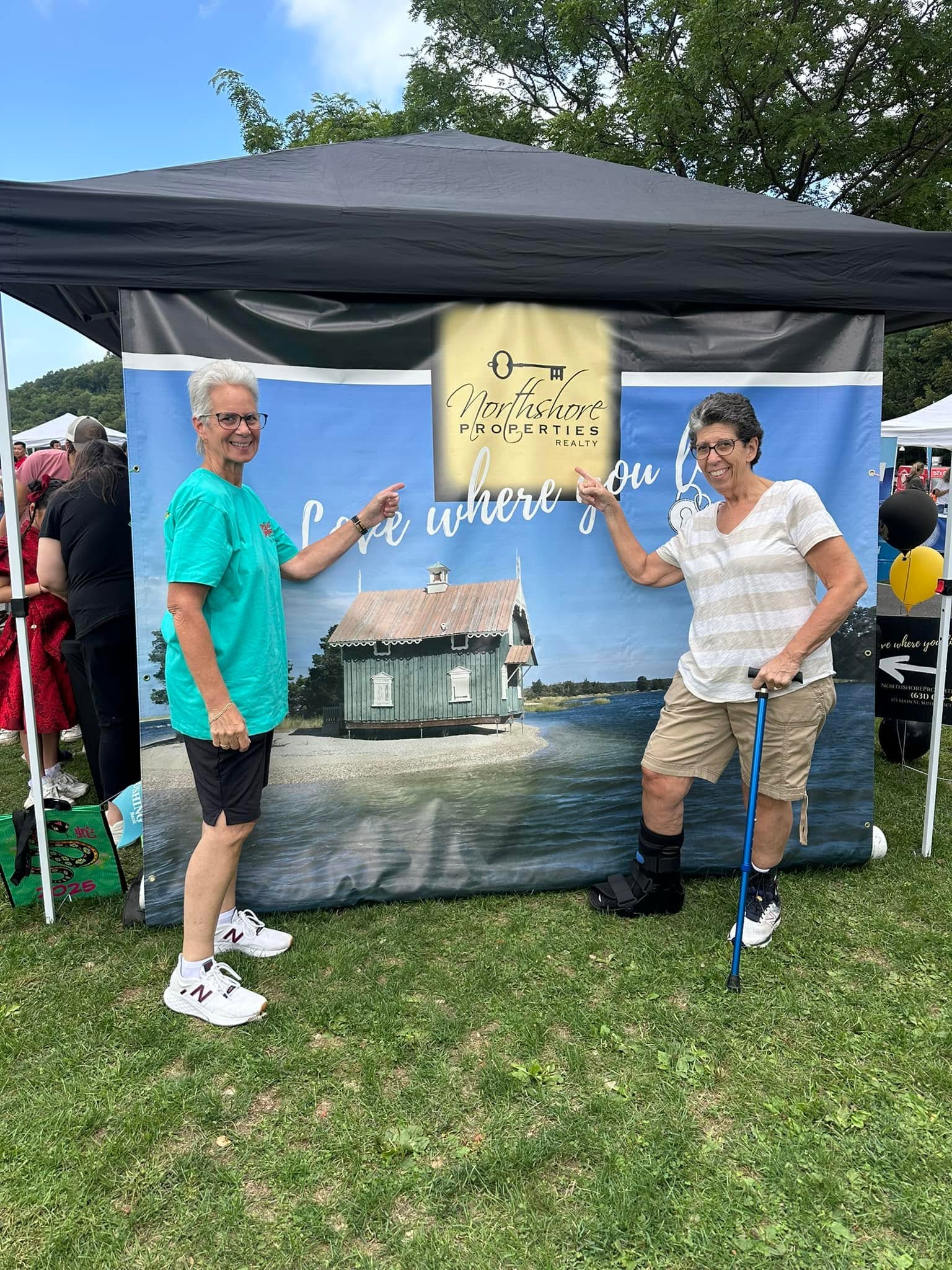 Visitors at the Northshore Properties Realty booth during the Port Jefferson Dragon Boat Festival