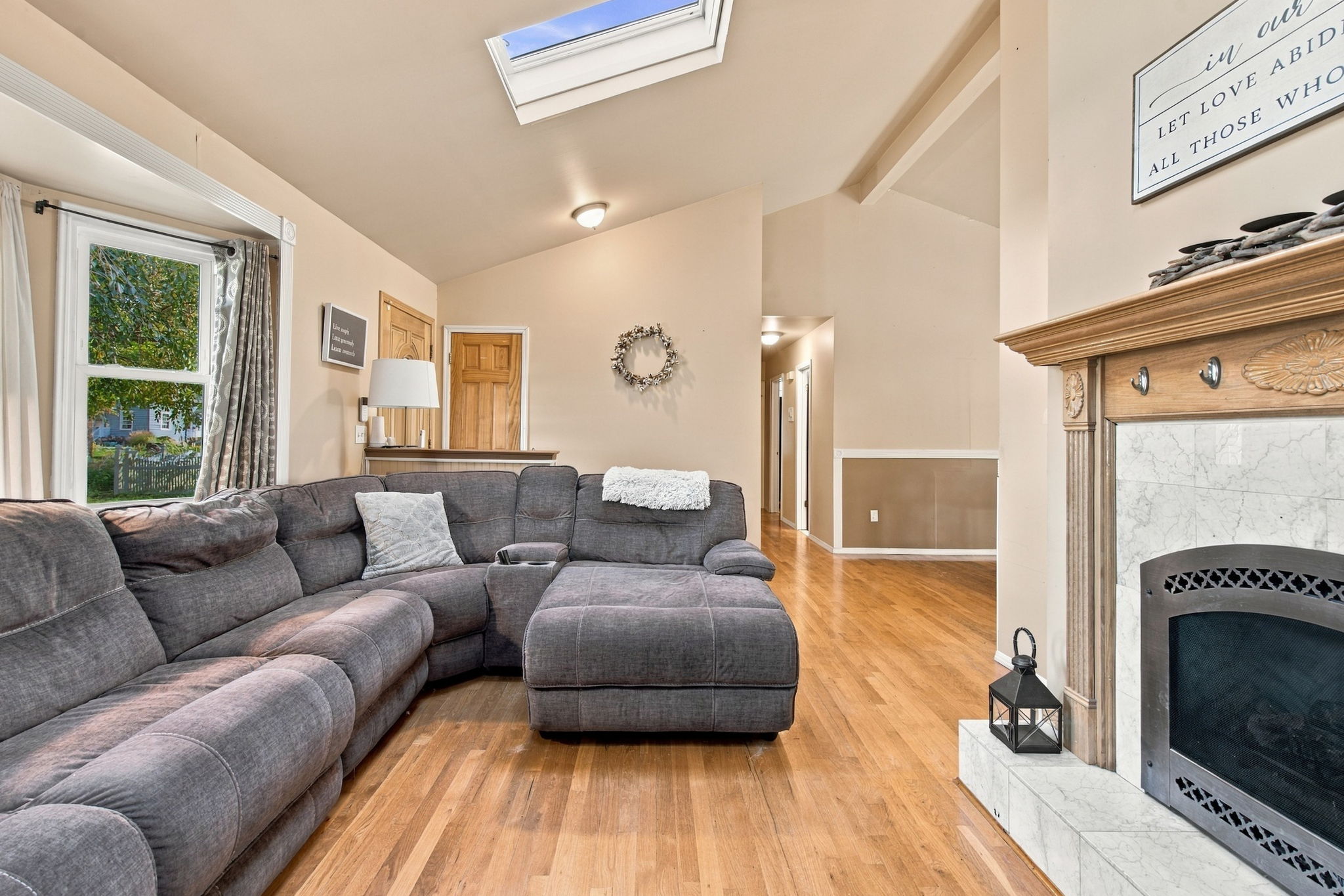 Living room with vaulted ceiling bay window and fireplace at 46 Cedar Street Selden NY